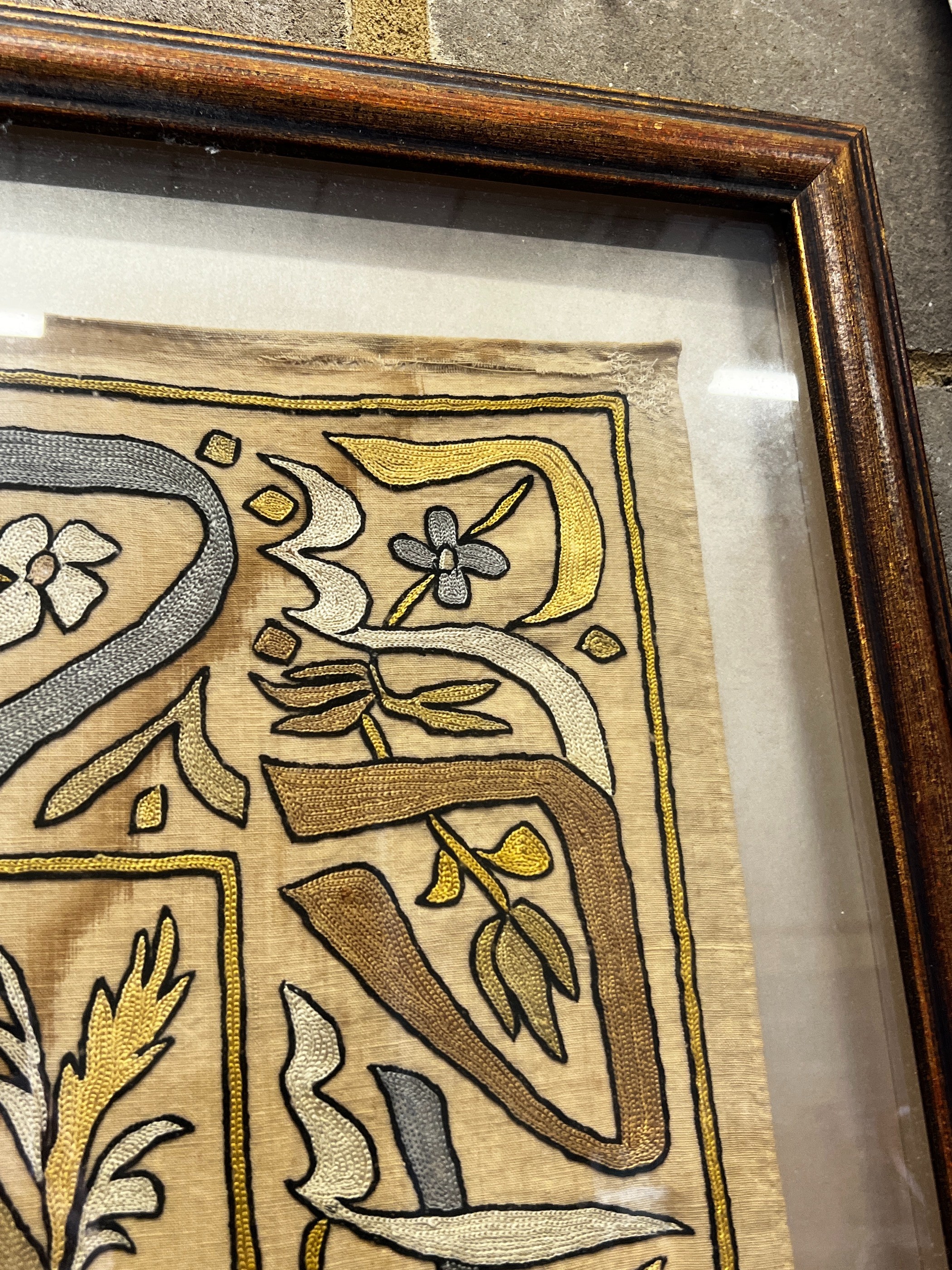 A polychrome embroidered panel, framed, the panel width 51cm, height 192cm